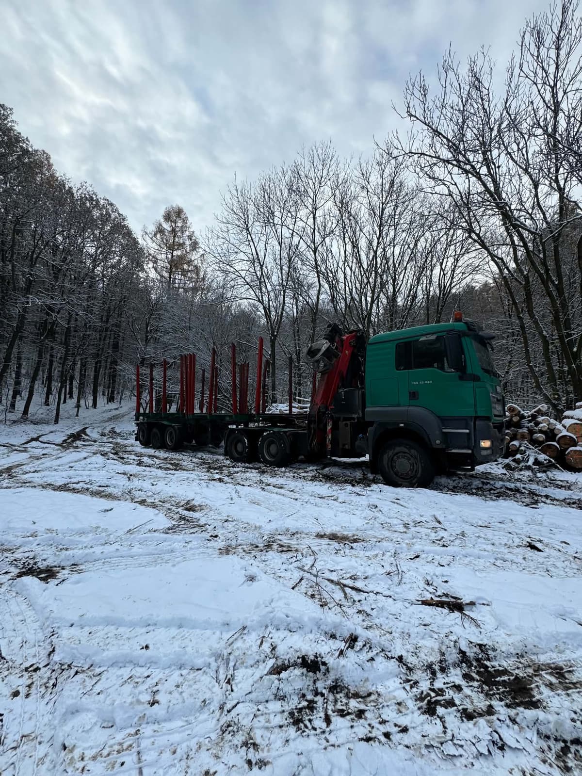 MAN s hydraulickou rukou v zasněženém lese