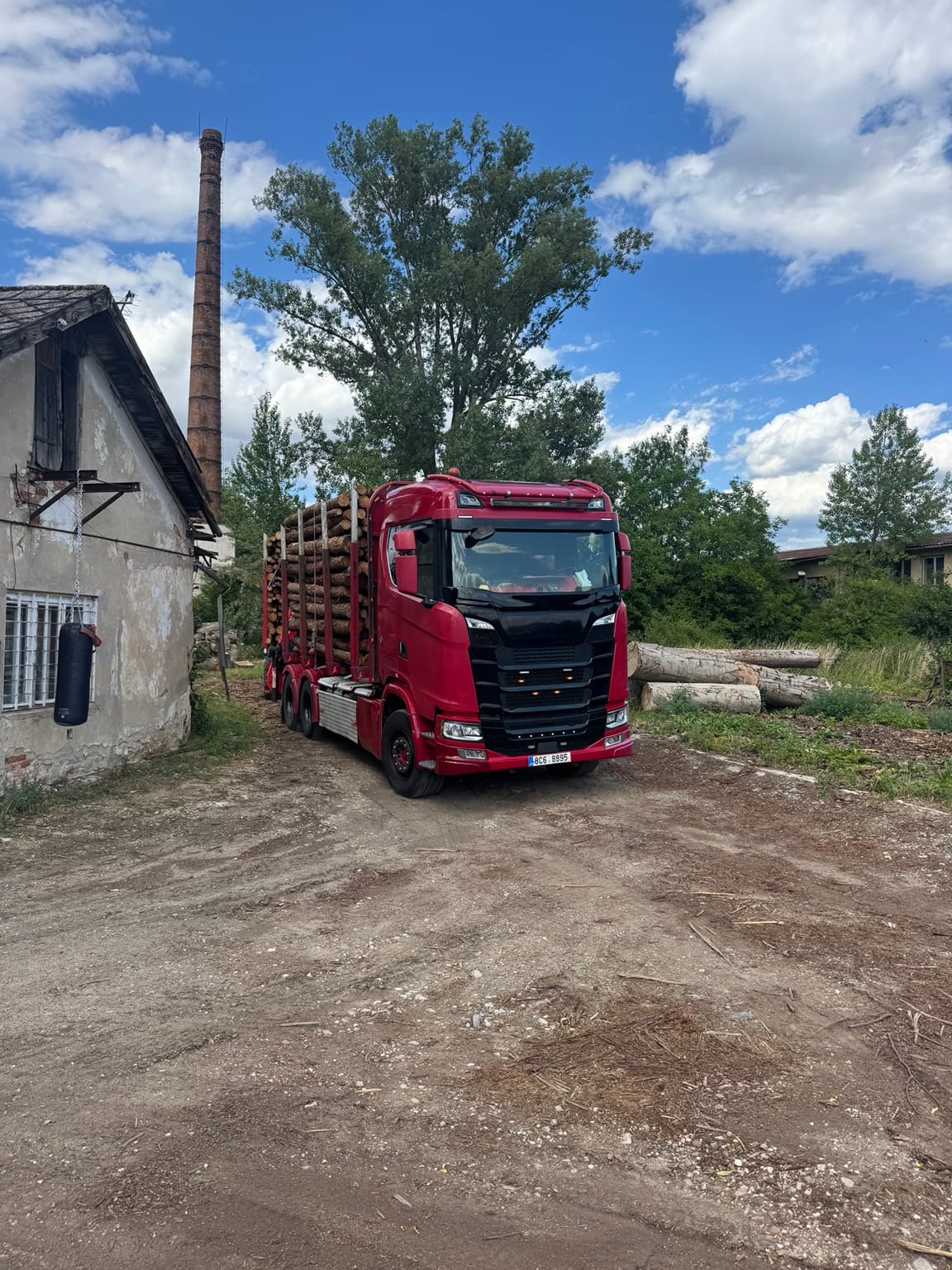 Červená Scania řady S s nákladem dřeva