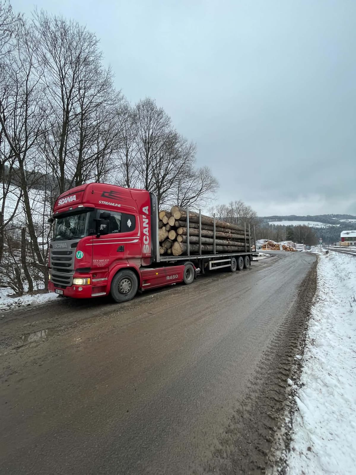 Scania R450 Streamline s návěsem plným kulatiny na zimní cestě